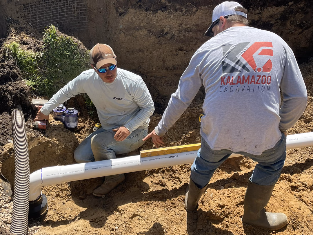 Two Kalamazoo Excavation crew members doing a sewer and water hookup
